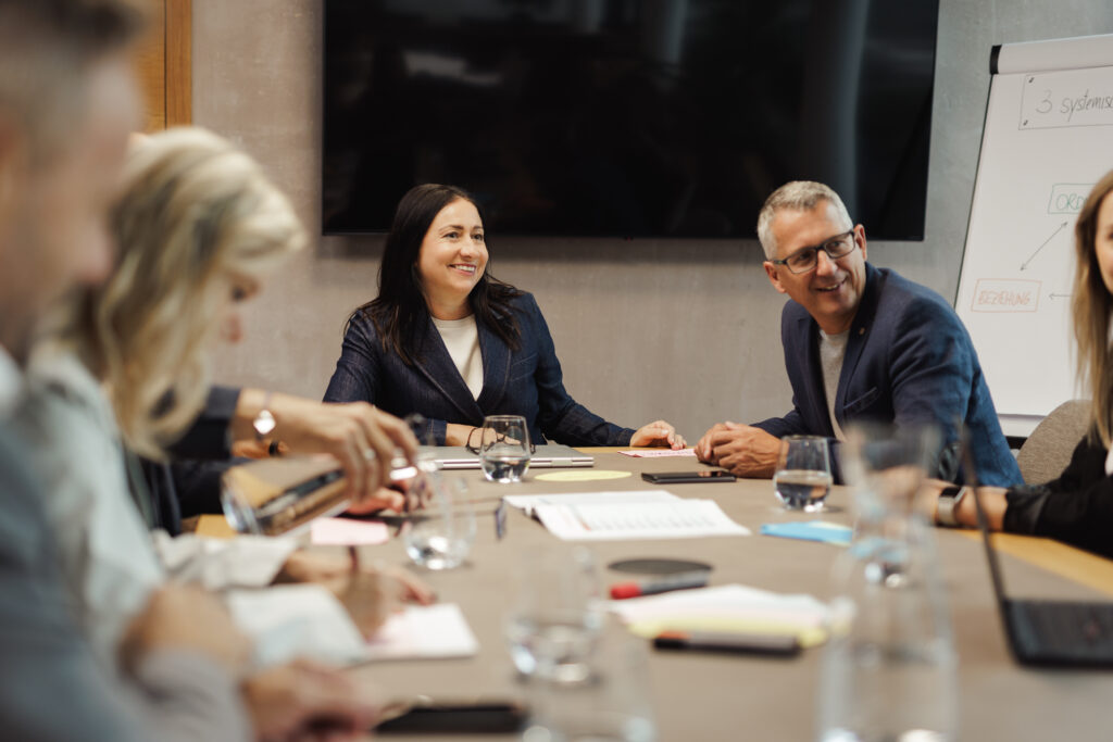 Teammeeting in modernem Besprechungsraum mit offener Kommunikation und aktiver Beteiligung